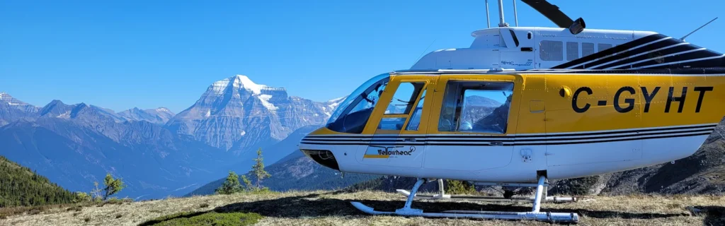 Bell 206B3 C-GYHT landed on mountaintop with Mt Terry Fox in the background