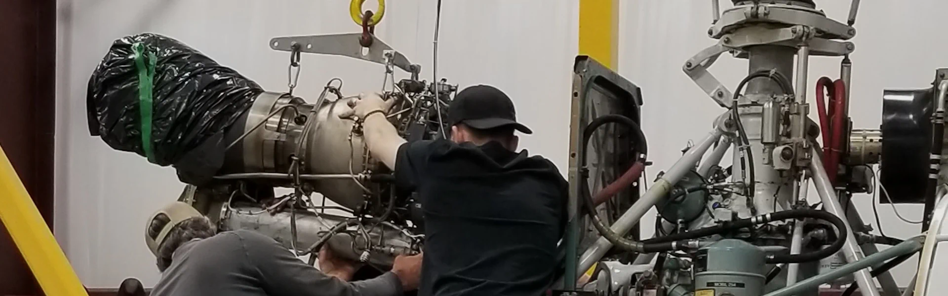 Photo of AMEs replacing engine in AS350 helicopter