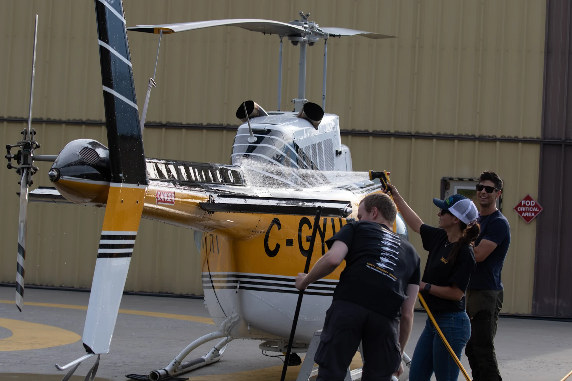 Photo of Valemount base helicopter crew washing a Bell 206