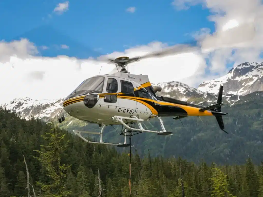 AS350 helicopter GYHZ rising in flight with sling