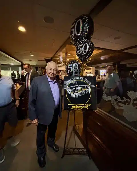 Garry Forman posing with 50th anniversary balloons