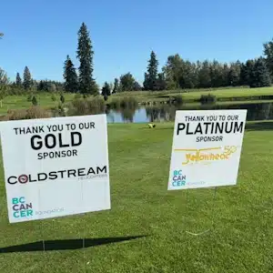 Charity golf tournament sponsor signs on the fairway