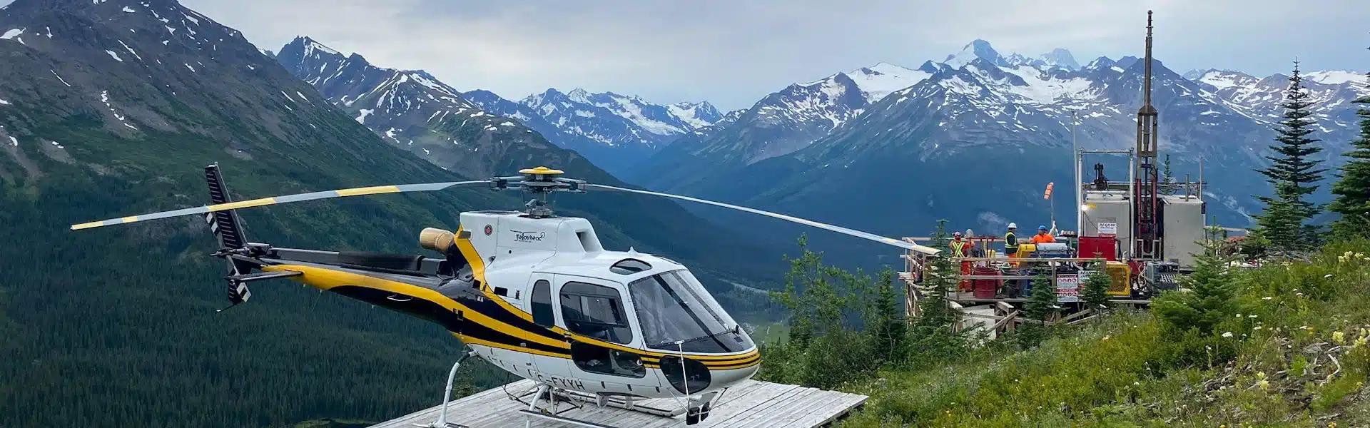 AS350 B3e helicopter parked on a mountaintop next to a drill pad in northern BC