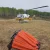 Bell 212 with bambi bucket parked in a field near Fort St John
